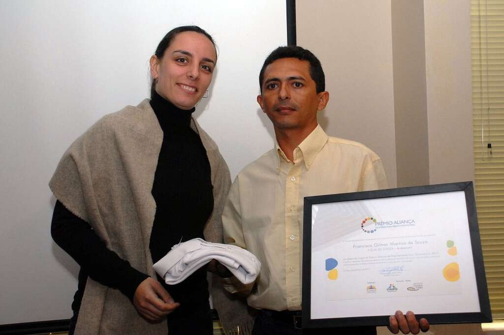 Diretora de Projetos da Aliança Empreendedora entregando o Prêmio para Gilmar Martins.